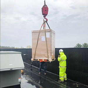 loading AC unit on rooftop